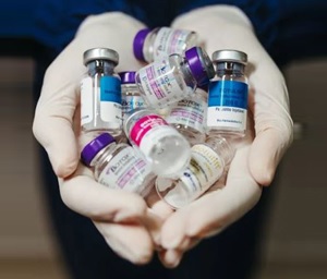 A person holding a bunch of medication bottles in their hands